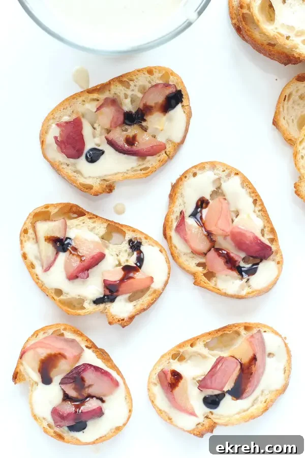 overhead view of sweet cream peach crostini drizzled with balsamic vinegar, on a white platter