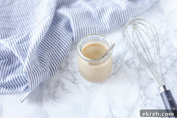 Homemade Sweetened Condensed Milk Recipe 6 homemade sweetened condensed milk in a jar with a whisk to the right