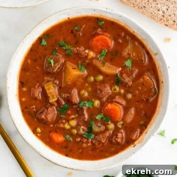 Vegan beef stew served in a bowl with bread and parsley around it.
