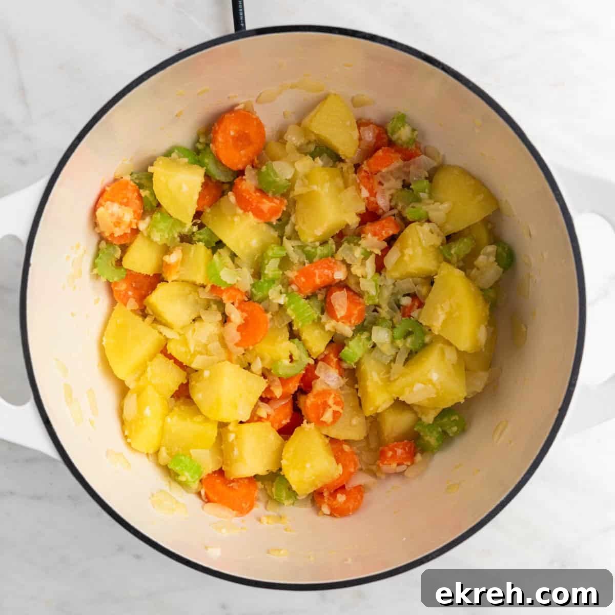 Hearty Vegan Beef-Style Stew with Plant-Based Chunks 6 Vegetables sautéed in olive oil in a large pot with flour added and browned.