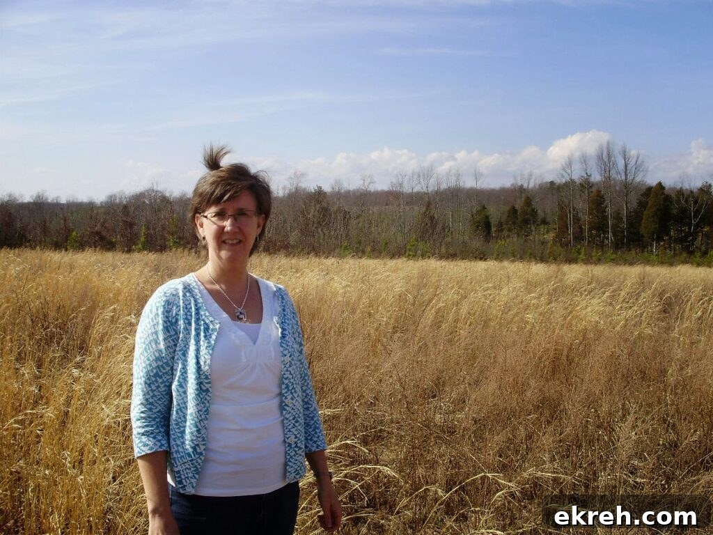 Woman standing in a field of broom straw.