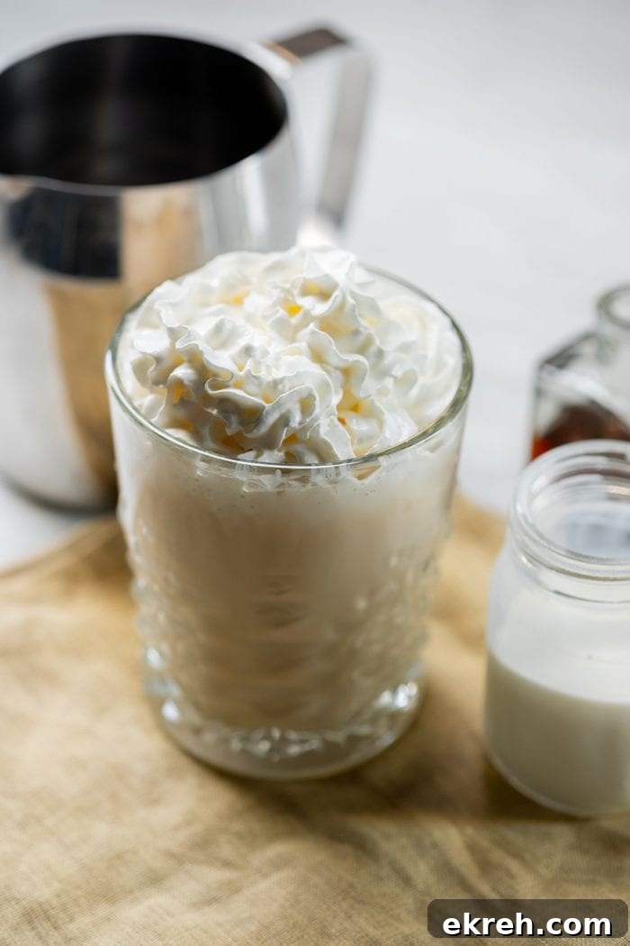 3-Ingredient Keto Whipped Cream Recipe 5 keto crack coffee keto coffee in a glass with whipped cream on top next to a pitcher