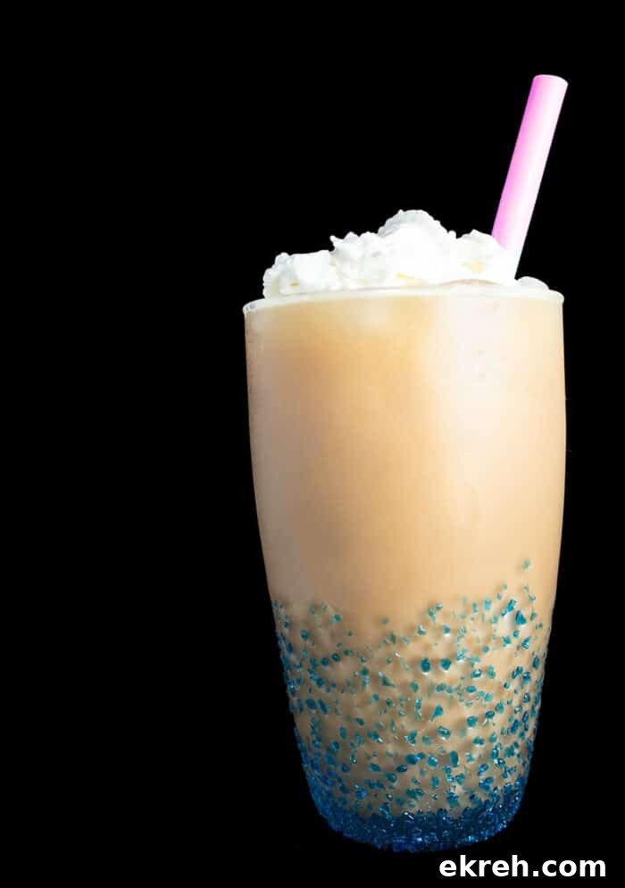 3-Ingredient Keto Whipped Cream Recipe 7 image of low carb iced coffee in blue tinted glass topped with whipped cream and a straw