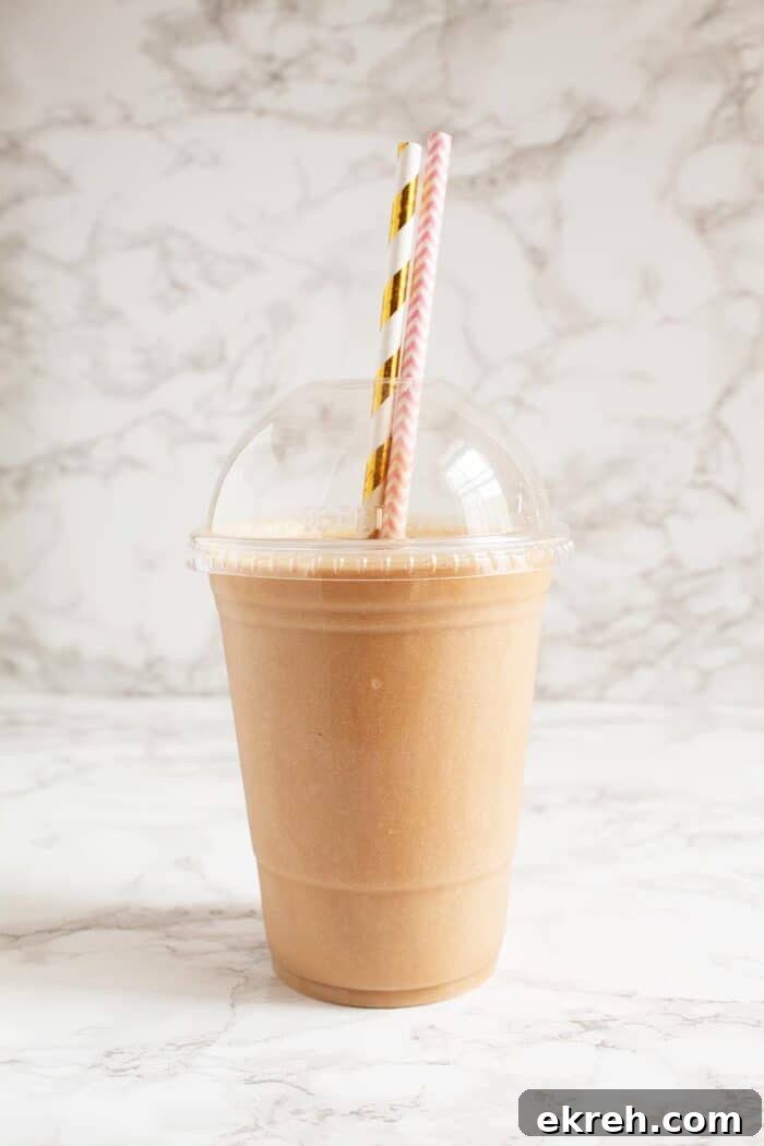 3-Ingredient Keto Whipped Cream Recipe 8 keto frappuccino in a plastic cup with two decorative straws in front of marble