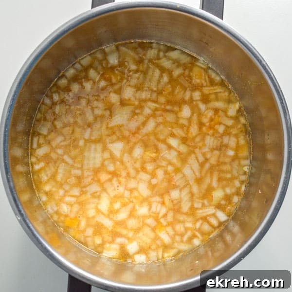 25-Minute Restaurant-Style Dal Tadka Recipe 5 Yellow water with chopped onions and lentils in a pot