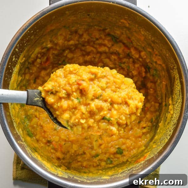 25-Minute Restaurant-Style Dal Tadka Recipe 8 A spoonful of cooked yellow lentils over a pot