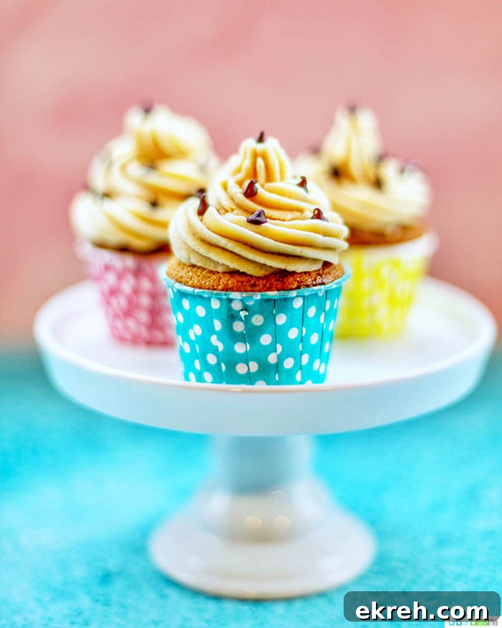 Chocolate Chip Cupcakes with Cookie Dough Frosting Recipe 5 trio of chocolate chip cupcakes with cookie dough frosting in colorful polka dot baking cups on a white pedestal