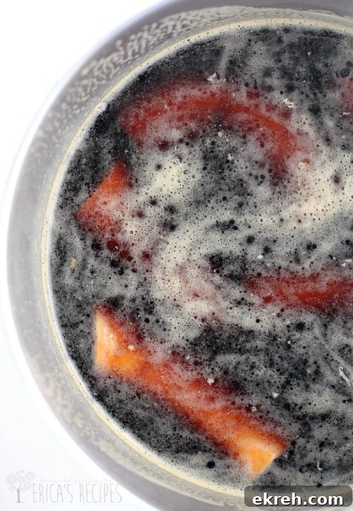 top down view of the polska kielbasa simmering in beer in a pot; white background