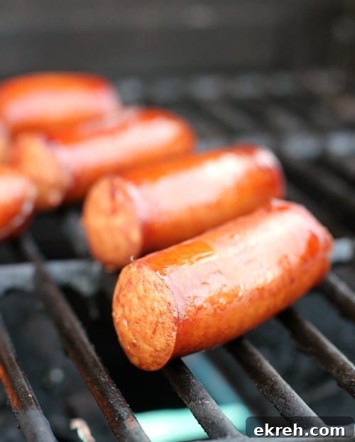 juicy beer brats cooking on the grill
