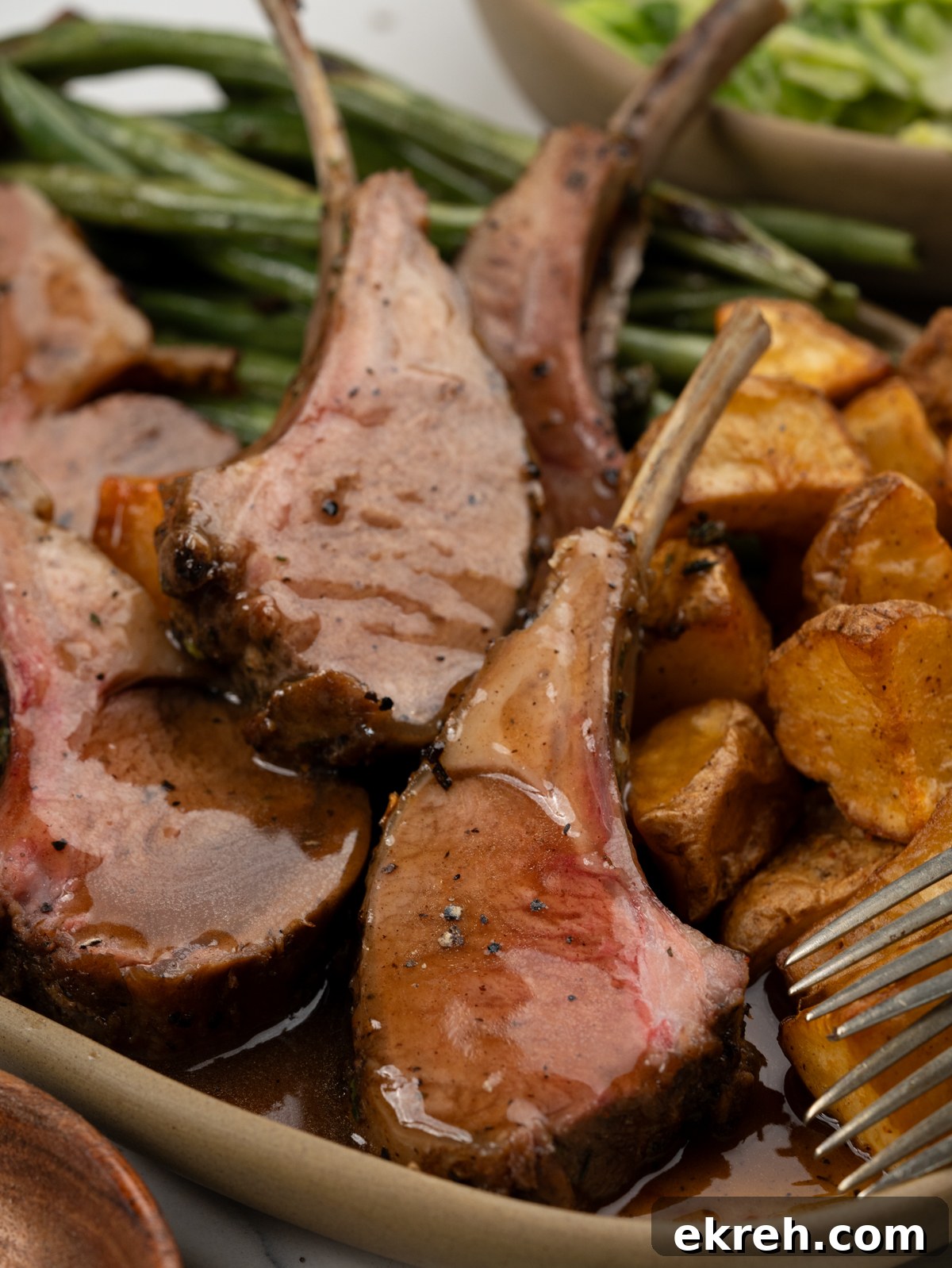 Carved lamb chops from a rack of lamb and served with gravy.