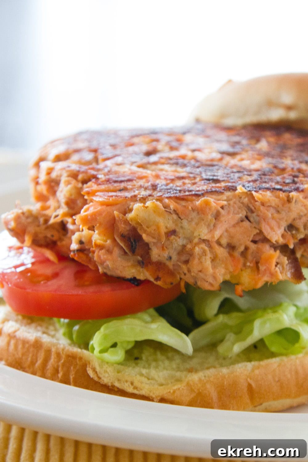 a close up on a burger on a bun made with salmon.