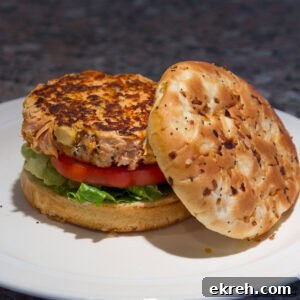 square crop of a salmon burger on a bun on a plate.