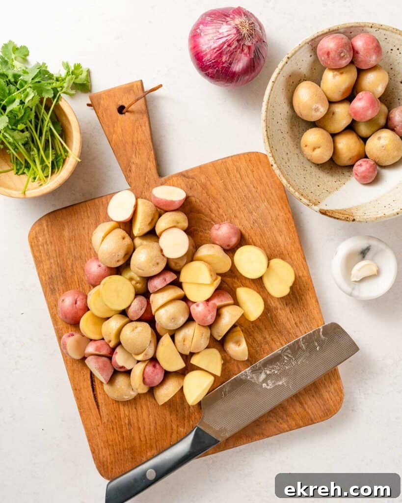 Classic Tuna and Potato Salad Recipe 4 baby potatoes cut in half on cutting board.