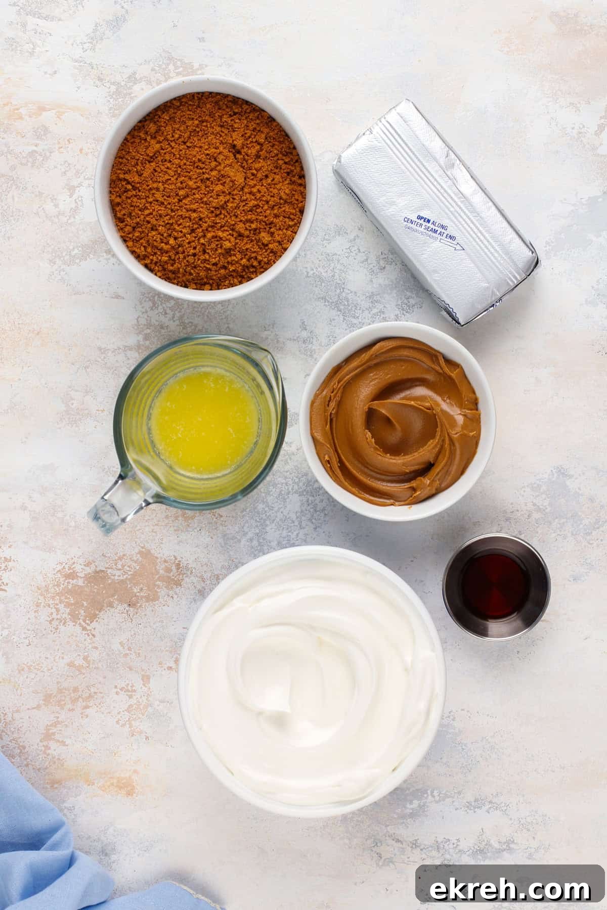 Ingredients for no-bake biscoff cheesecake arranged on a countertop.
