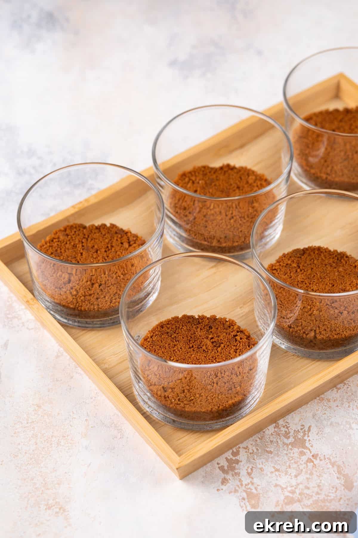 Biscoff cookie crust pressed into the bottom of glass ramekins.