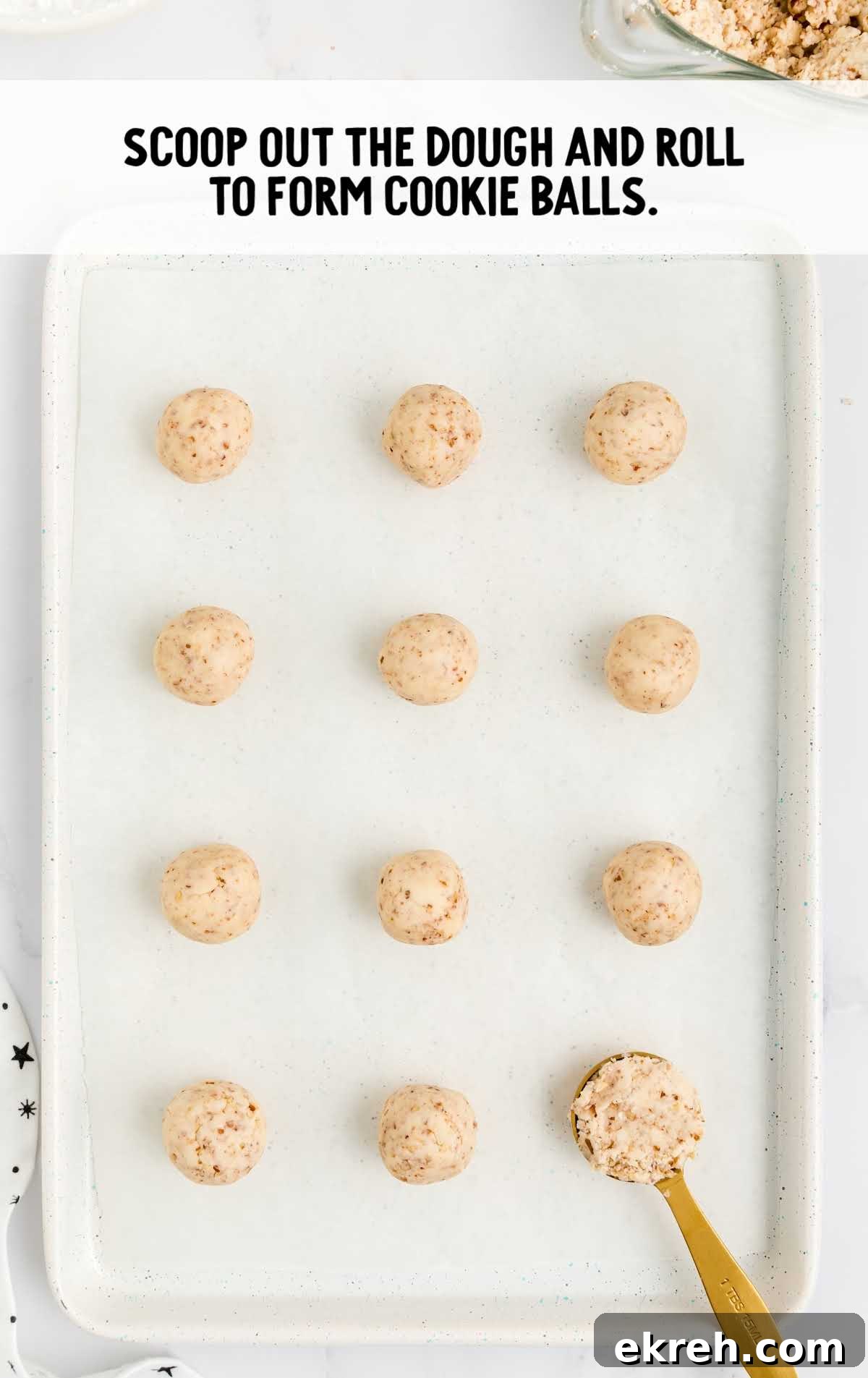 Snowball Cookies process shot of cookie dough balls scooped onto a sheet pan