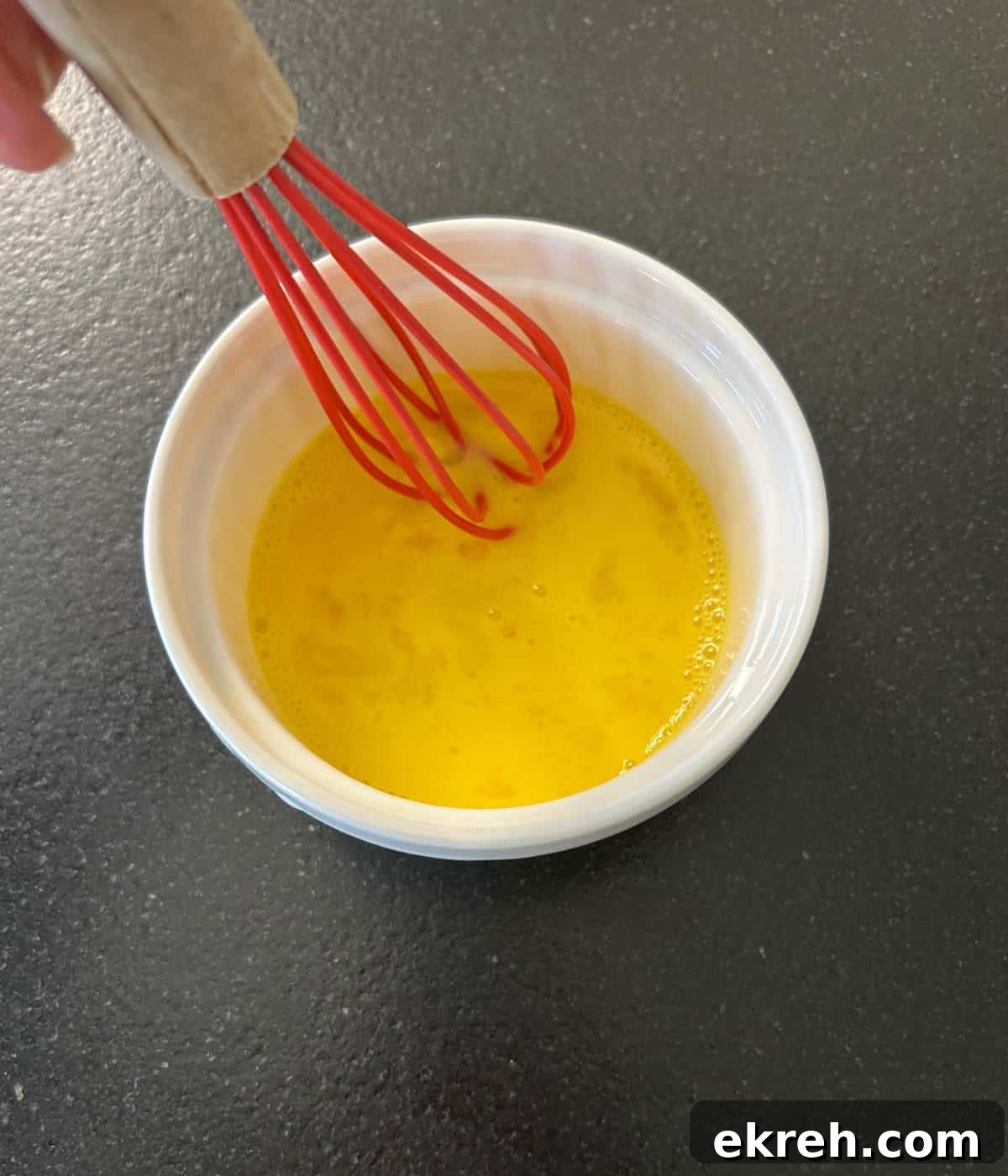 Egg and water whisked in bowl to create an egg wash.