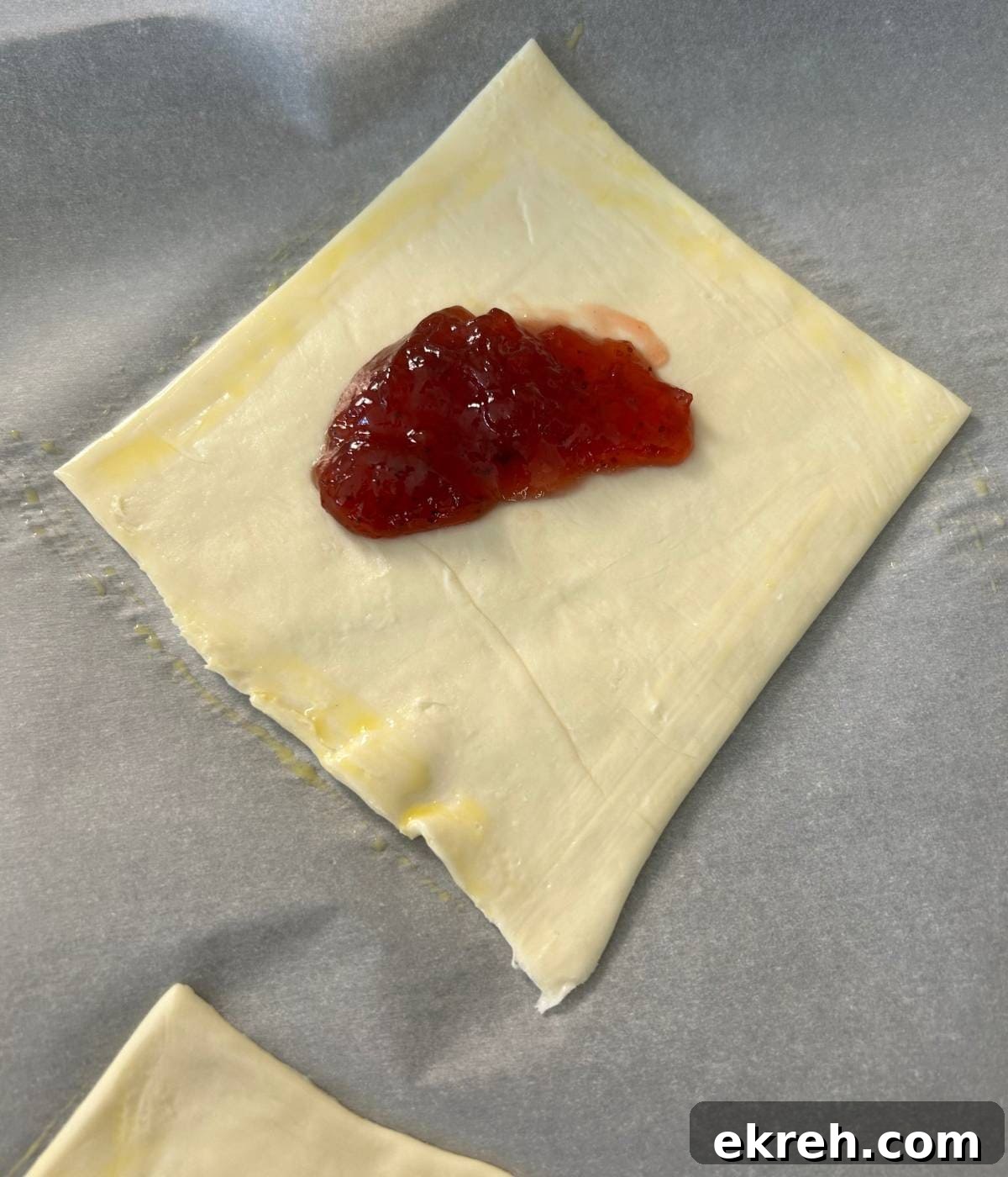 Puff pastry square with filling in center and egg wash.