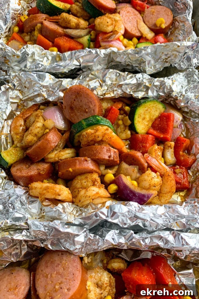 Close up of cajun shrimp foil packets on a baking sheet.