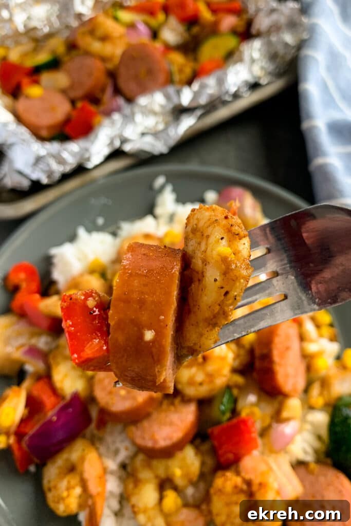 Close up of cajun shrimp and sausage on a fork.