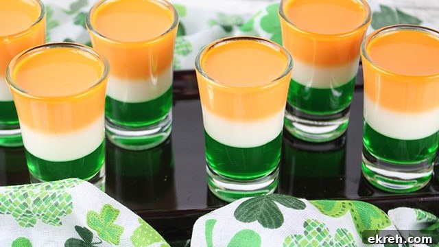 St. Patrick's Day jello shots staggered on a black plate with a shamrock fabric
