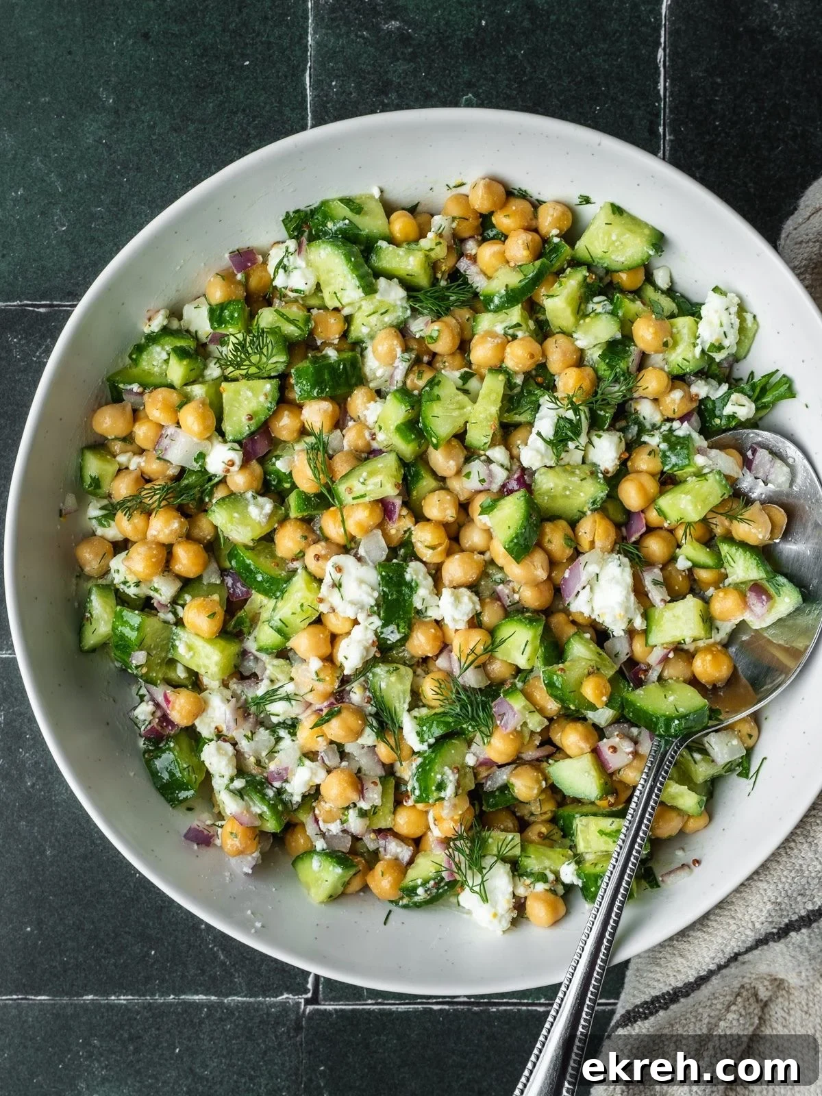 Mediterranean Cucumber, Chickpea and Feta Salad 2 Cucumber chickpea and feta chopped salad in a bowl garnished with dill.