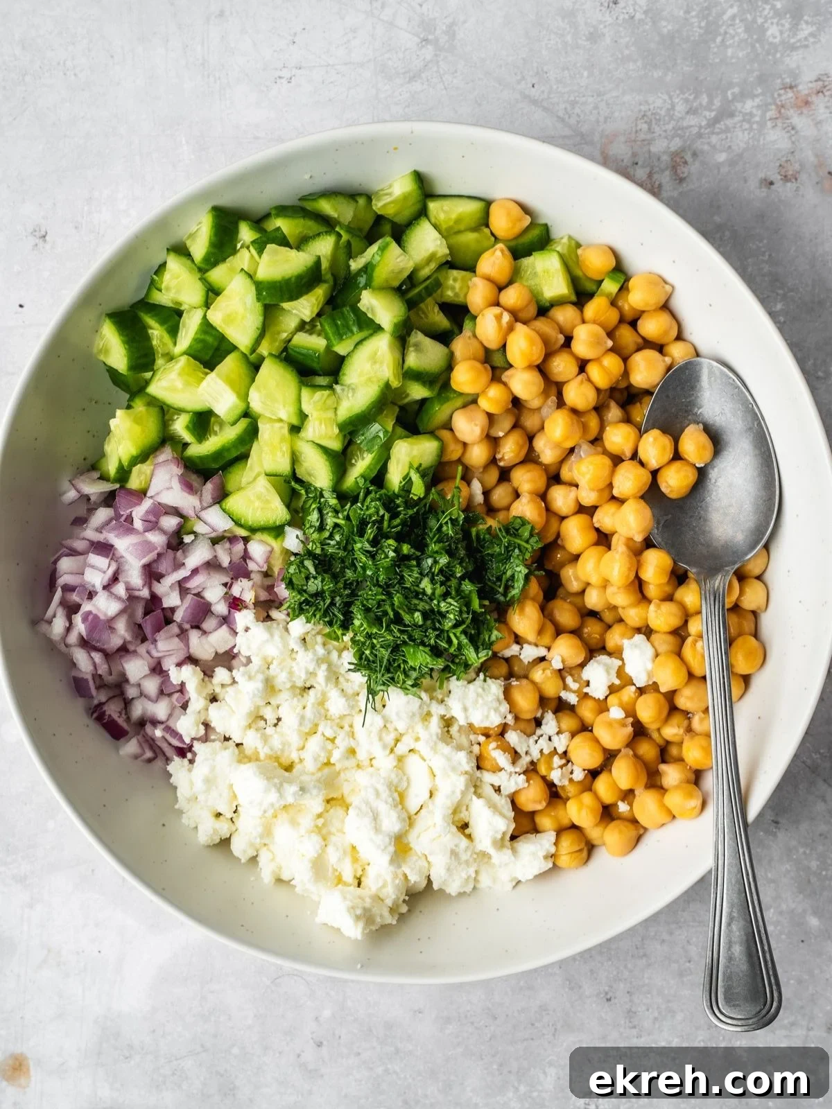 Mediterranean Cucumber, Chickpea and Feta Salad 5 Chopped cucumbers, chickpeas, red onion, feta and herbs in a bowl.