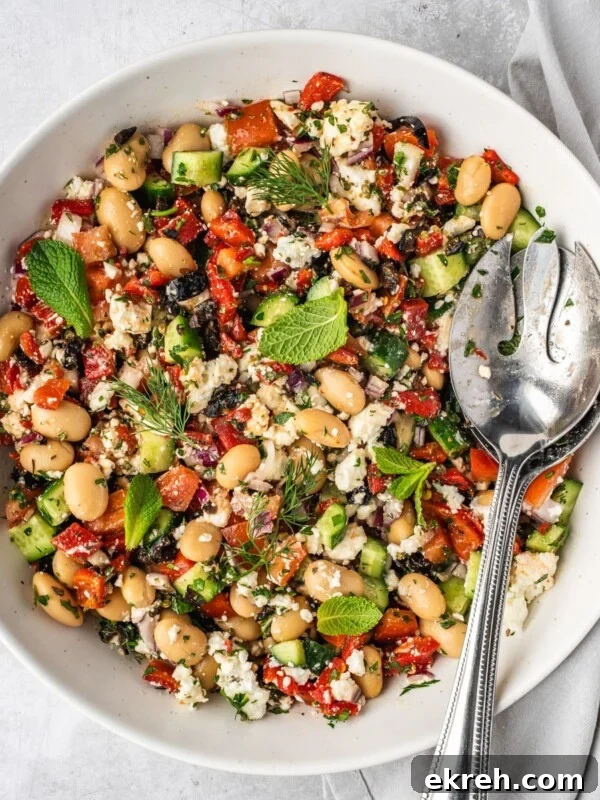 Greek butter bean salad garnished with fresh mint leaves and fresh dill fronds in a large serving bowl.