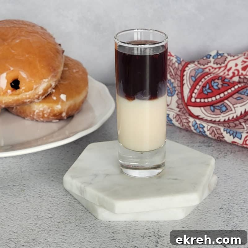 Layered Jelly Donut shot next to a jelly doughnut and napkin