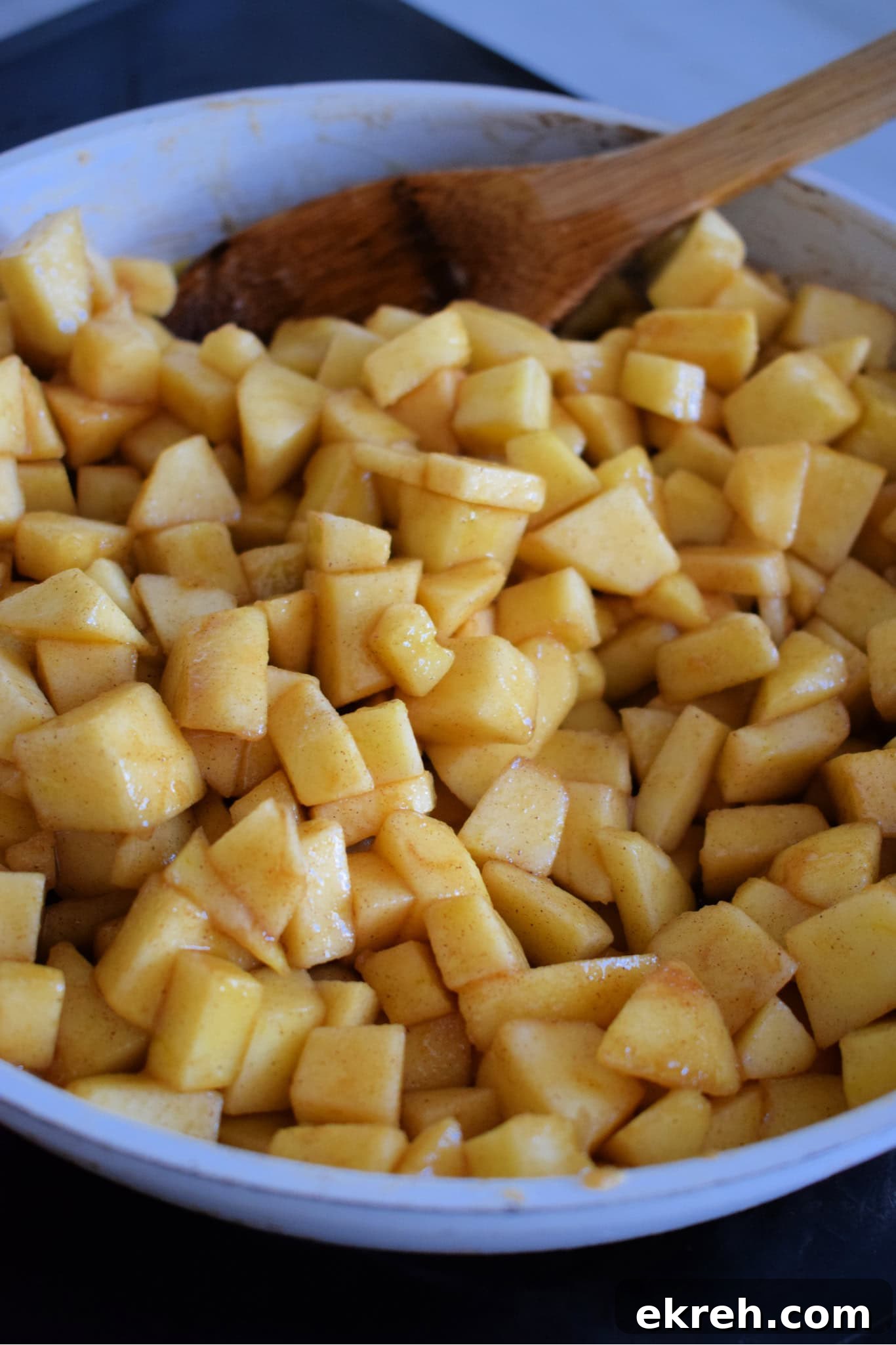 Diced apples in a skillet with brown sugar and butter.