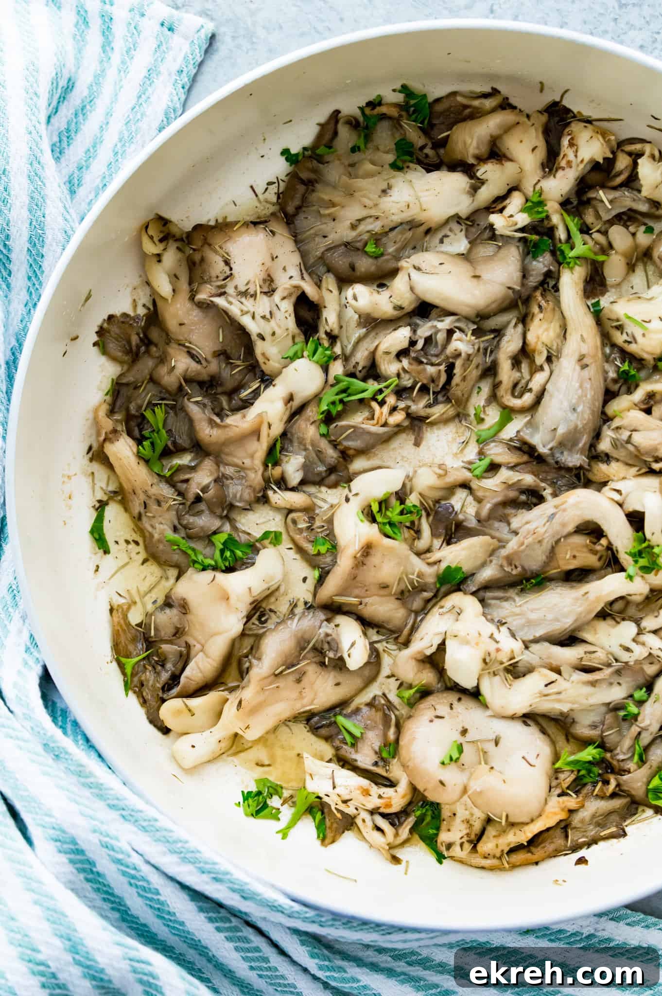 A pan filled with fried oyster mushrooms topped with fresh herbs.