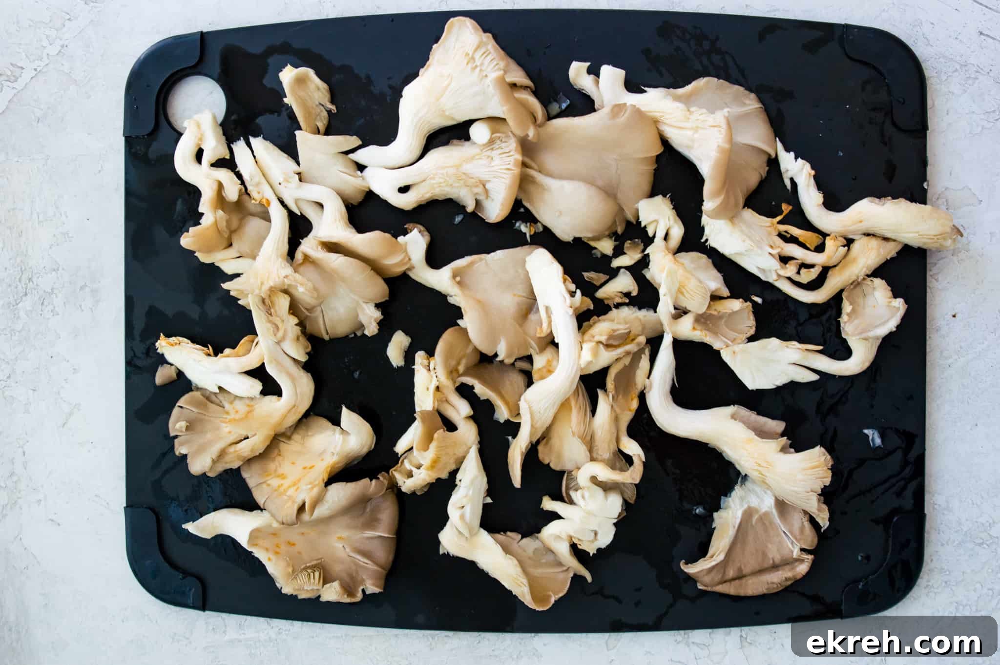 Cut oyster mushrooms on a cutting board.