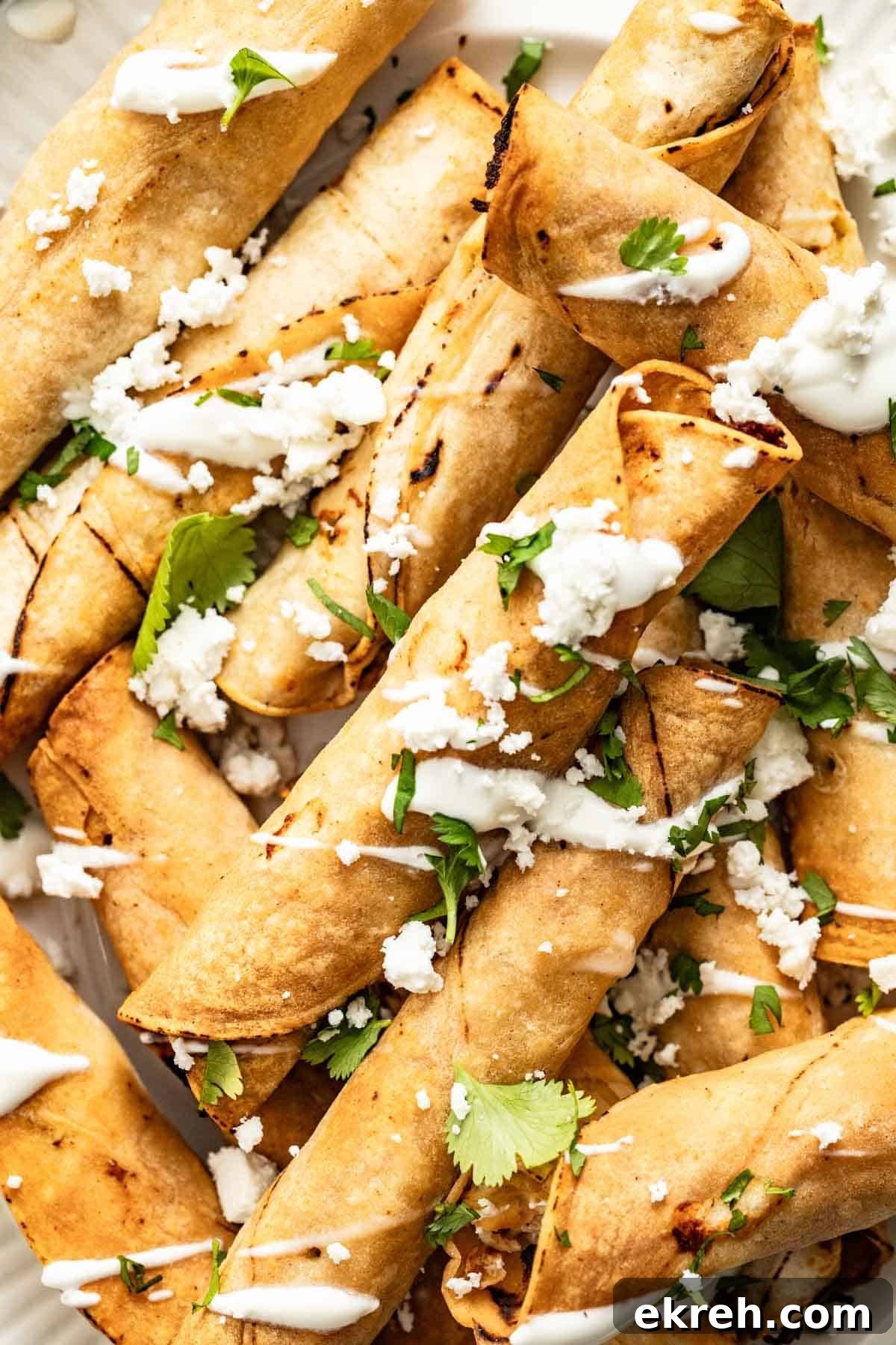 How to Make Crispy Air Fryer Chicken Taquitos 8 A stack of chicken taquitos topped with queso fresco.
