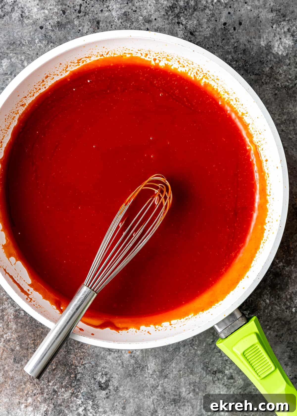 Homemade Sweet and Sour Sauce Recipe for Stir-Fries and Dipping 5 overhead: mixing sweet and sour sauce in white pan with whisk