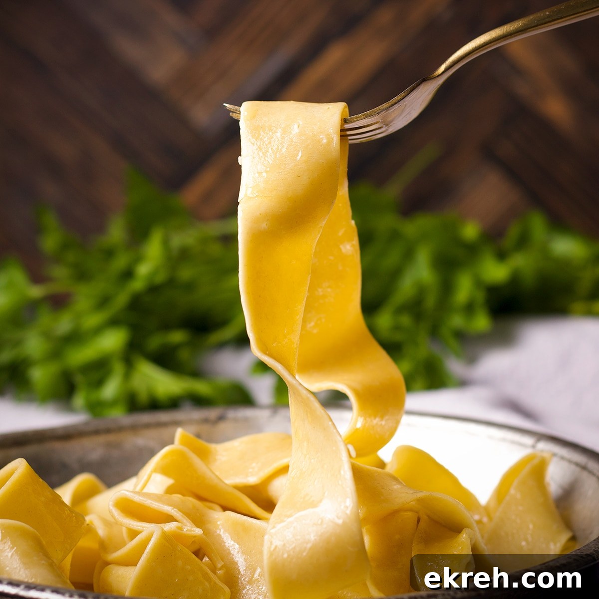 Someone using a fork to lift a cooked pappardelle noodle from a tin plate.