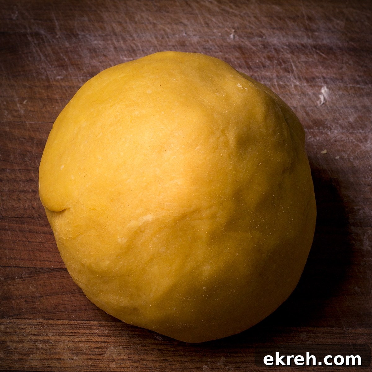A ball of homemade pasta dough that's been kneaded until it's smooth.