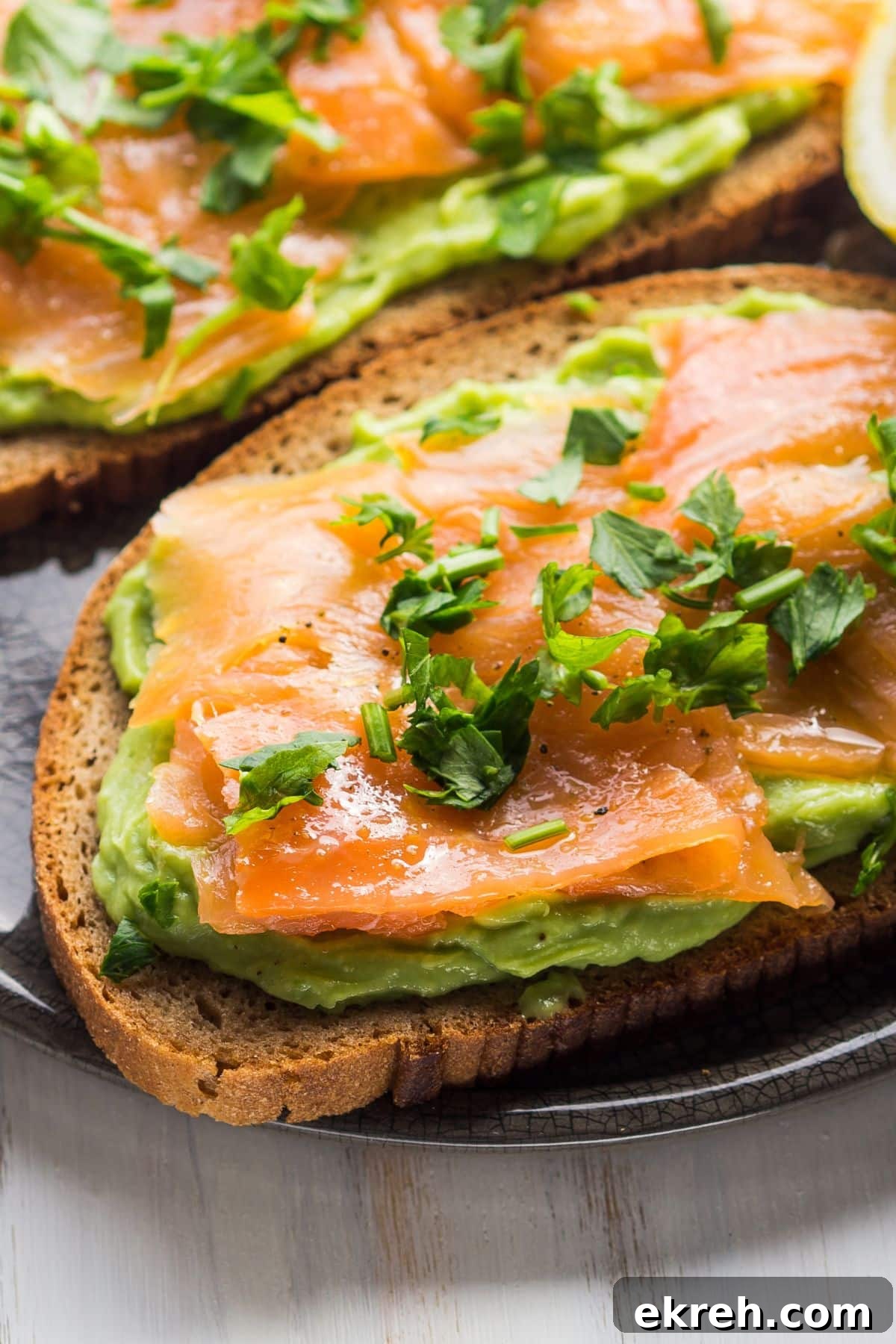 close-up of smoked salmon avocado toast sprinkled with parsley