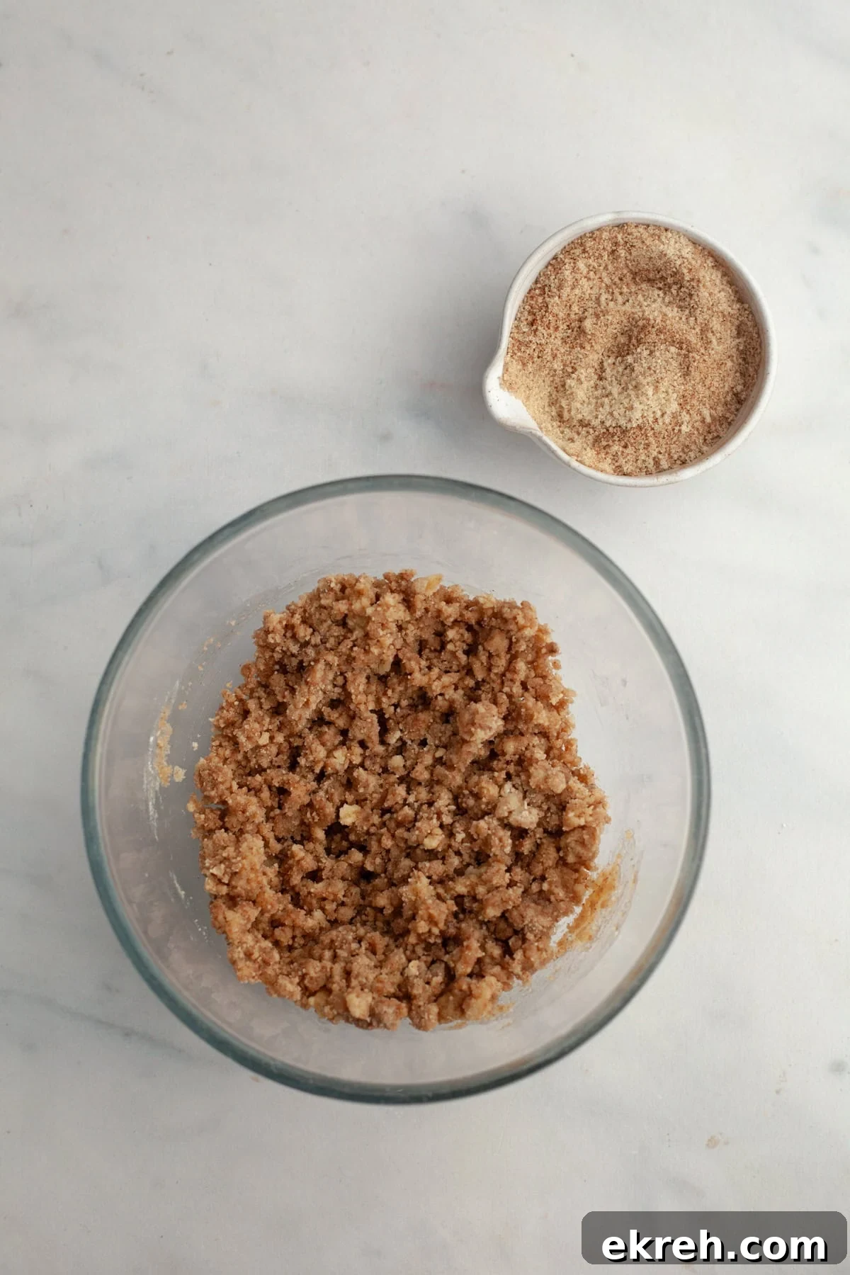 Streusel in a glass bowl and a small bowl with cinnamon sugar.