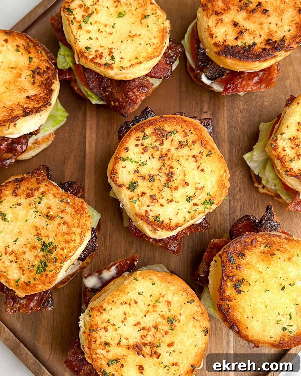 Candied Bacon BLT Sliders with Maple Glaze 9 blt sliders on a brown cutting board