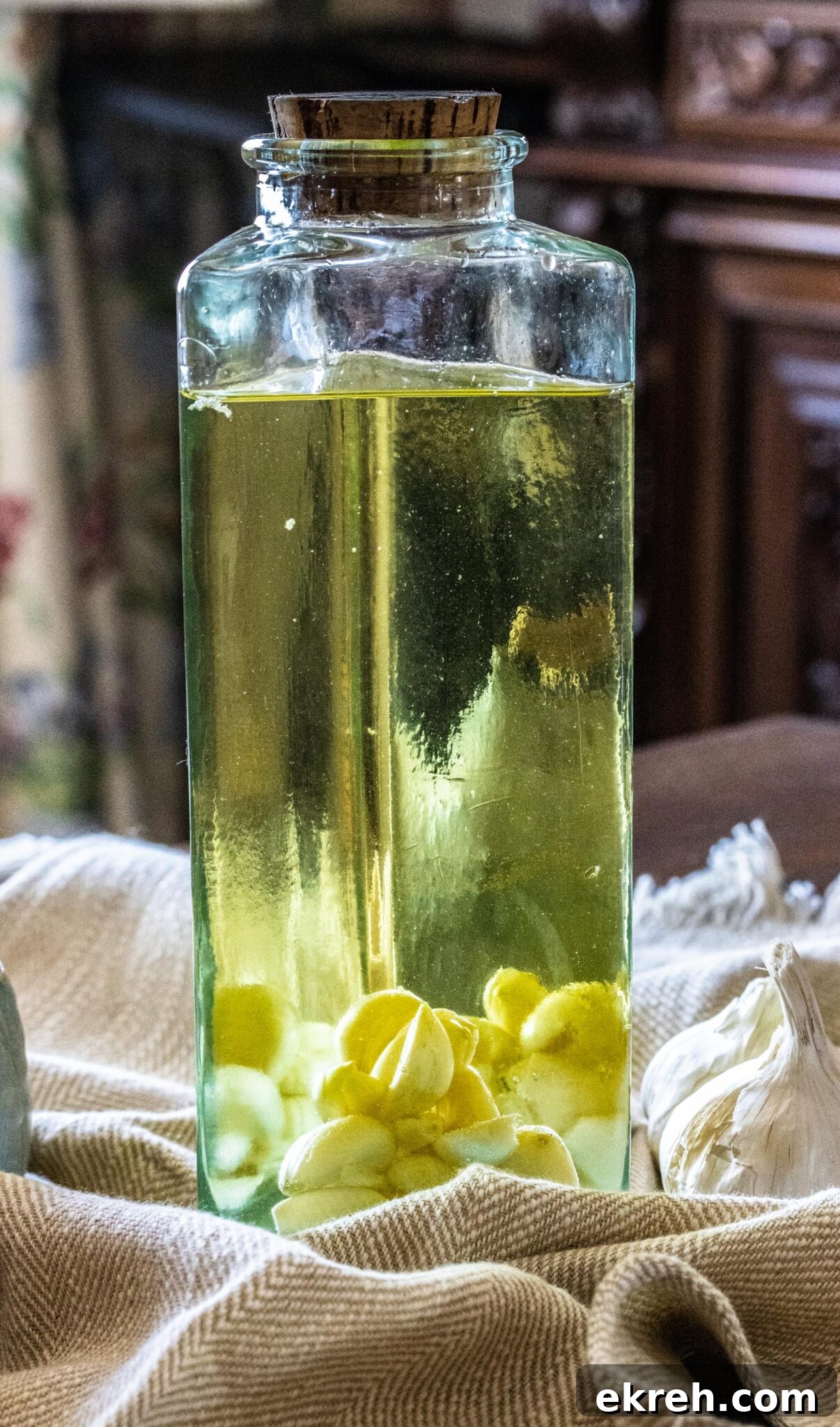 How to Make Garlic Infused Olive Oil at Home 2 The oil in a glass bottle with pieces of garlic at the bottom.