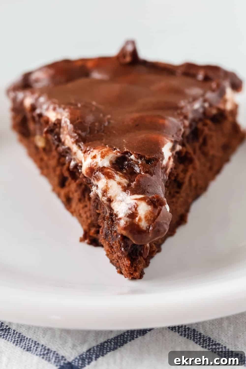 Classic Appalachian Fudge Brownie Pie Recipe 11 close-up view of a wedge slice of appalachian brownie fudge pie, showing melted marshmallows and chocolate icing over the brownie layer.