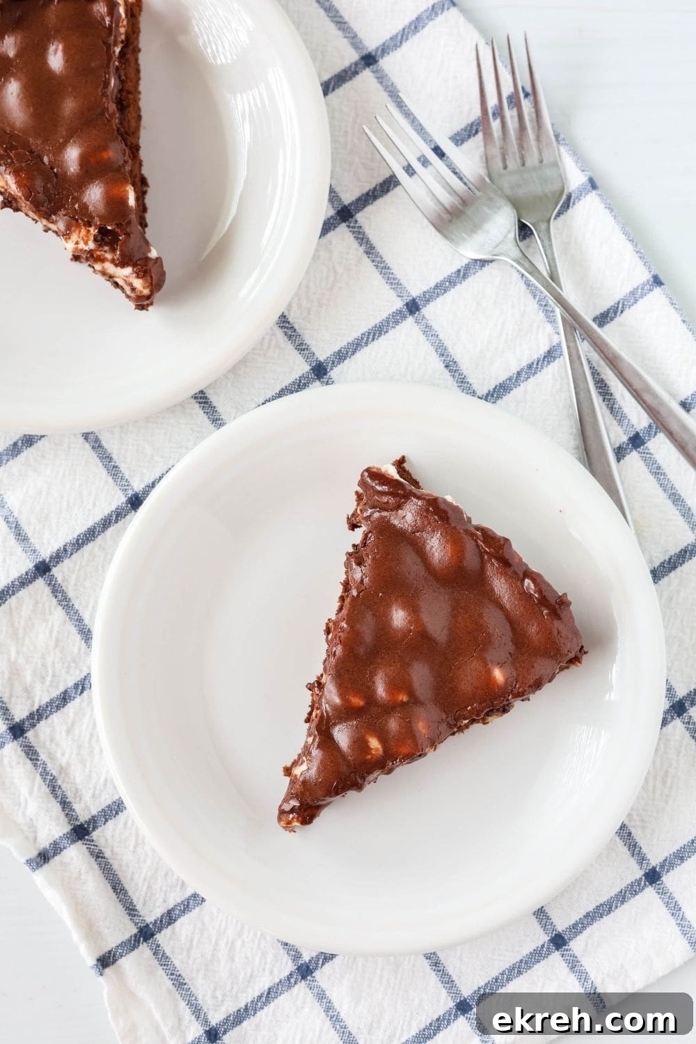 Classic Appalachian Fudge Brownie Pie Recipe 4 overhead view of two slices of Appalachian brownie pie, each served on a white plate, with forks next to the plates.