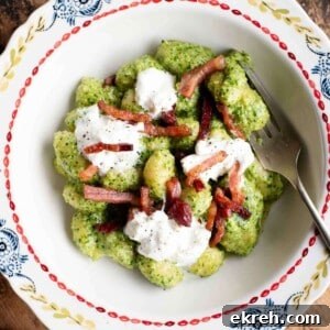 Arugula Pesto Gnocchi with Creamy Burrata and Crispy Pancetta 11 An cropped image of arugula pesto gnocchi in a bowl topped with pancetta and burrata.