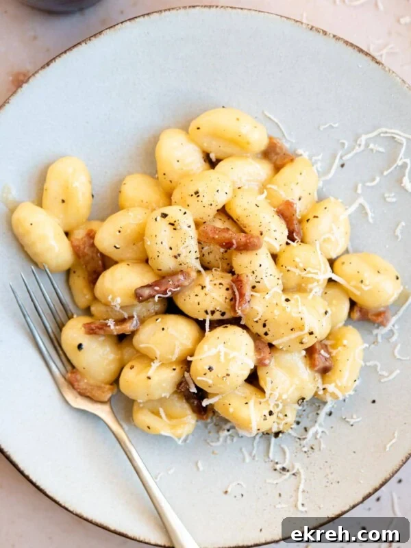 Arugula Pesto Gnocchi with Creamy Burrata and Crispy Pancetta 8 An overhead shot of a plate of gnocchi with carbonara sauce