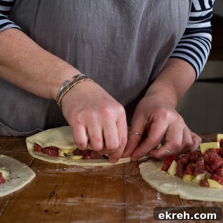 How to Make a Traditional Cornish Pasty (Authentic Recipe) 12 womans hands making three Cornish pasties on a wooden kitchen counter