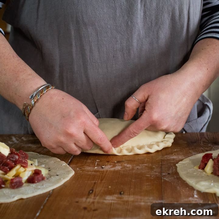 How to Make a Traditional Cornish Pasty (Authentic Recipe) 14 womans hands crimping the crust of a traditional Cornish pasty