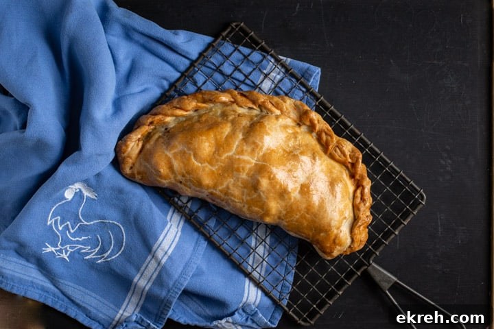 How to Make a Traditional Cornish Pasty (Authentic Recipe) 3 black background with blue cloth and golden Cornish pasty