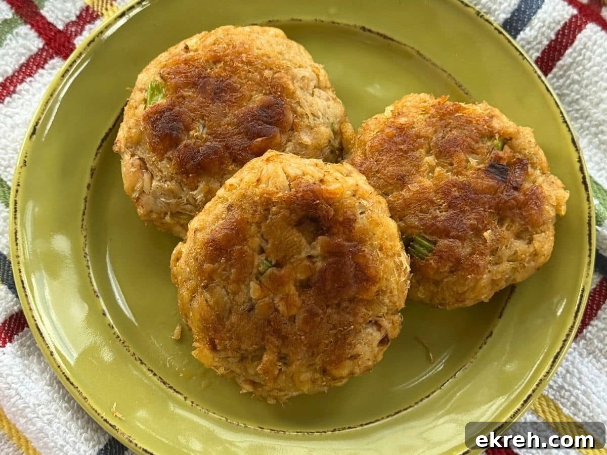 Three Maryland crab cakes on a green plate.