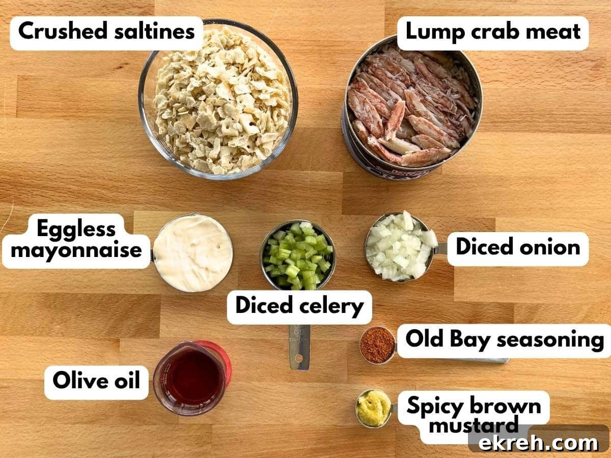 Ingredients to make eggless crab cakes: lump crab meat, crushed saltines, eggless mayonnaise, diced celery, diced onion, Old Bay seasoning, spicy brown mustard, and olive oil.