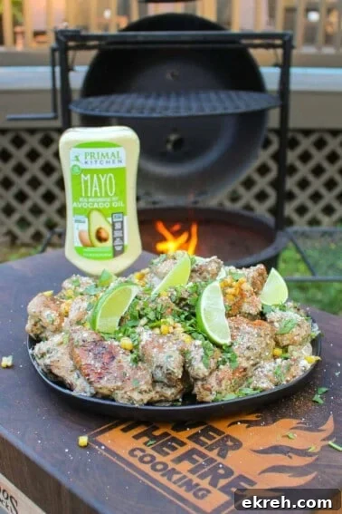a plate of elote style chicken wings with a bottle of mayo in the background